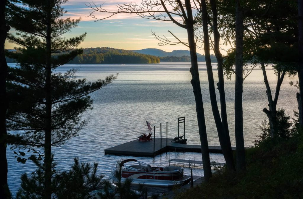 A lake with a dock and trees in the background.