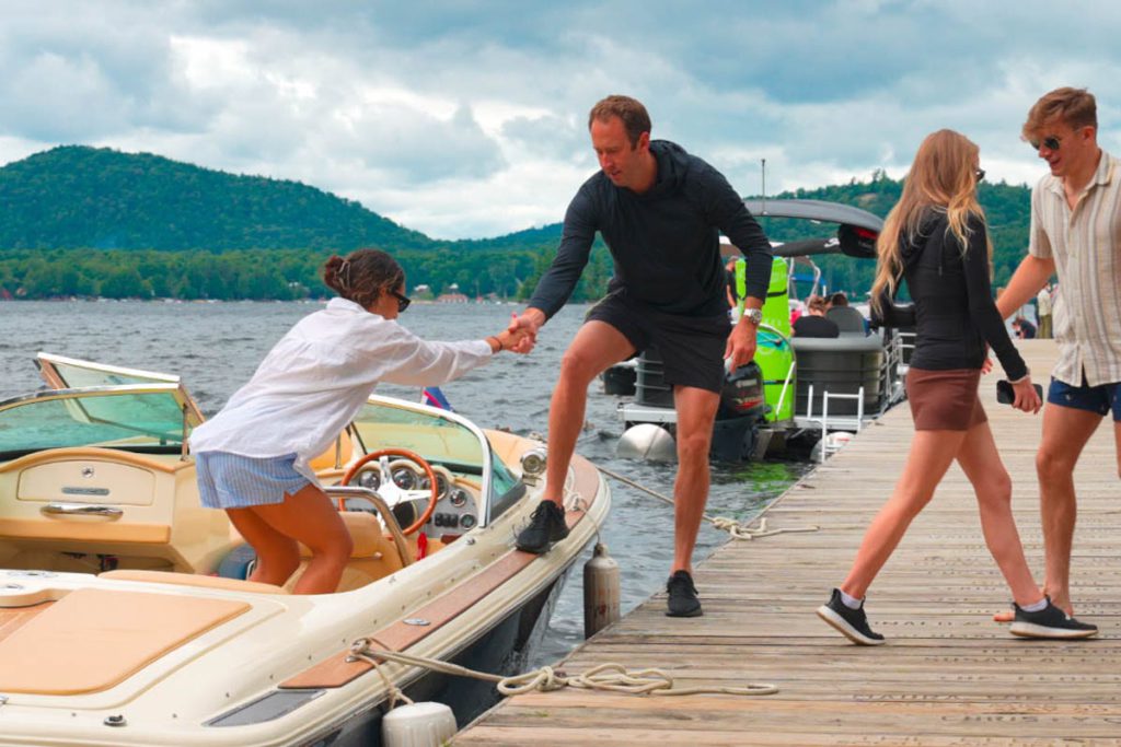 A group of people standing on a dock next to a boat.