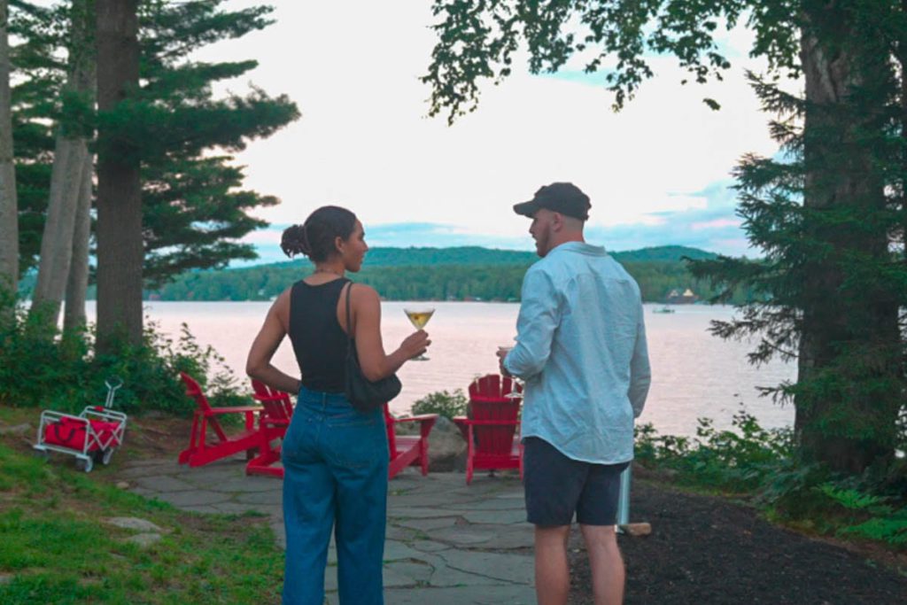 Two people standing on a path near a lake.